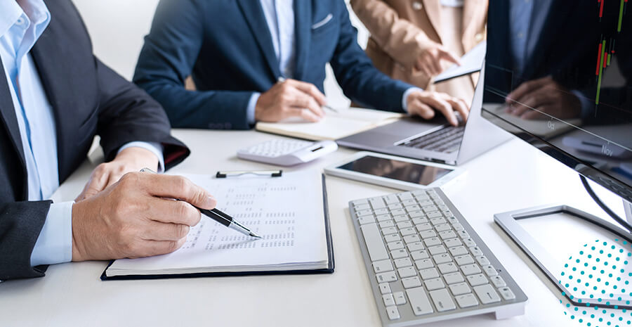 imagens de pessoas em uma mesa com agenda e computadores.