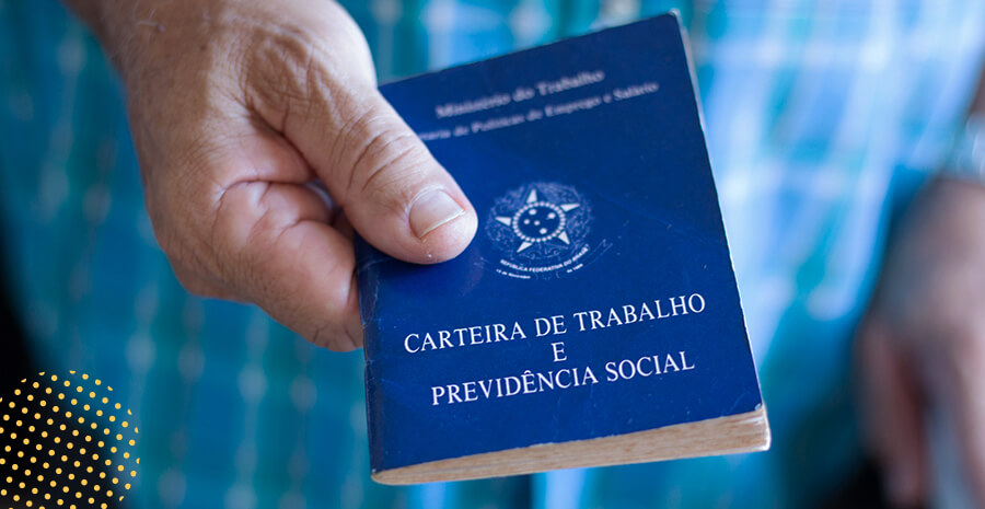 imagem de uma mão segurando uma carteira de trabalho
