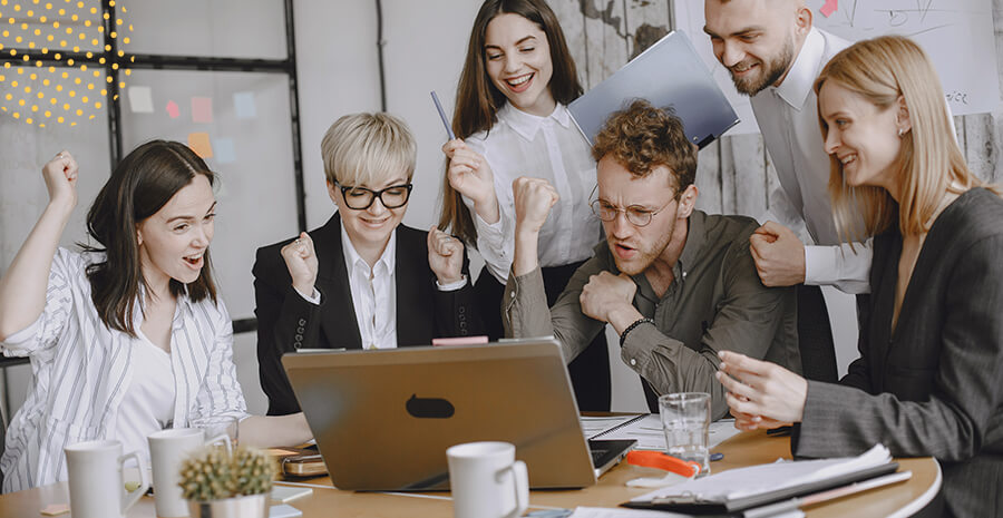 imagem de pessoas no trabalho comemorando em frente ao computador