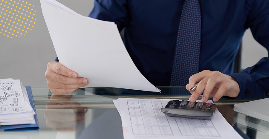 imagem de uma pessoa segurando um papel e usando uma calculadora