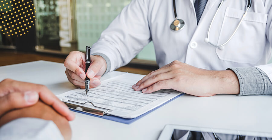 imagem de um médico preenchendo uma fixa de exame periódico