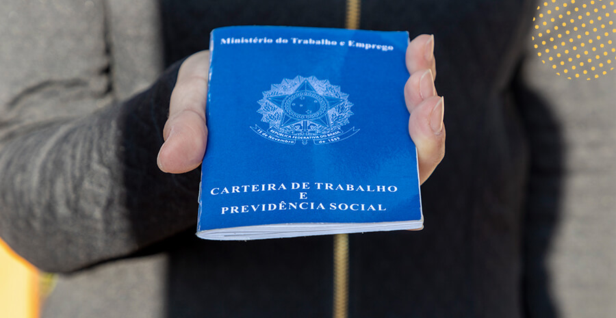 imagem de uma pessoa segurando uma carteira de trabalho fechada