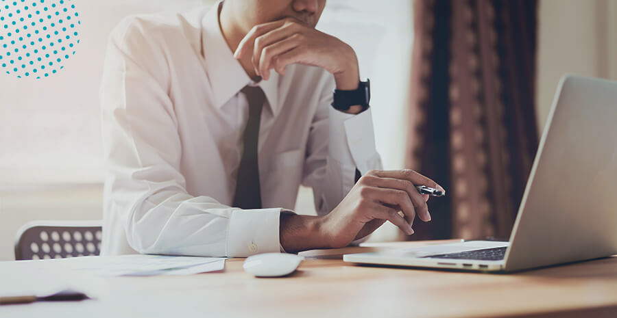 imagem de um homem, com roupas sociais mechendo no computador