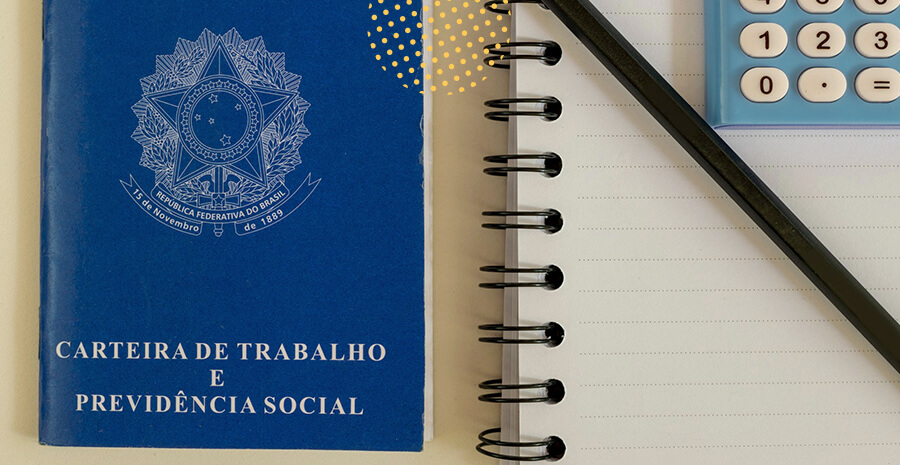 imagem de uma carteira de trabalho ao lado de um caderno com uma calculadora em cima