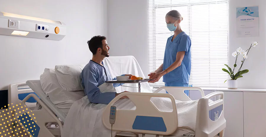 imagem de um paciente em uma cama de hospital conversando com uma enfermeira