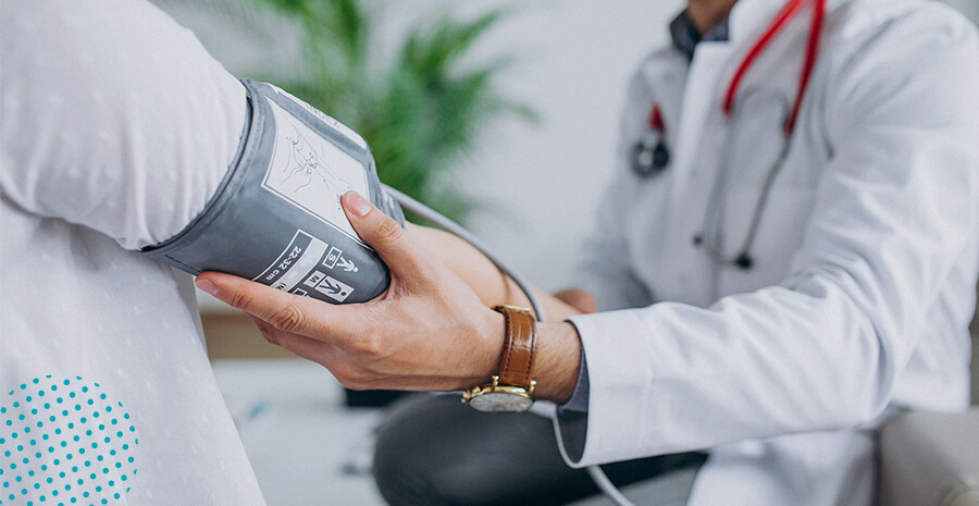 imagem de um médico aferindo a pressão de um paciente