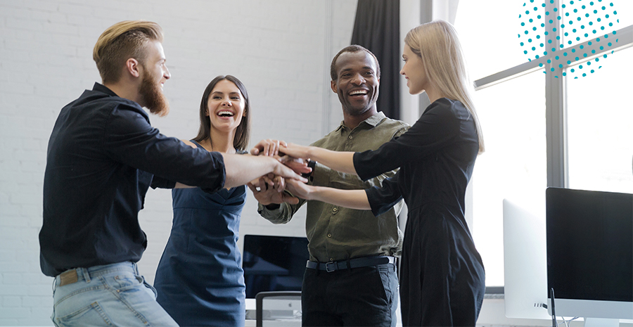 imagem de quatro pessoas em pé juntando as mãos felizes e comemorando