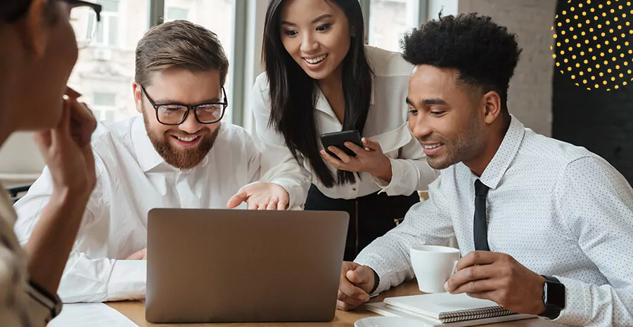 imagem com três pessoas diferentes conversando e apontando para o notebook