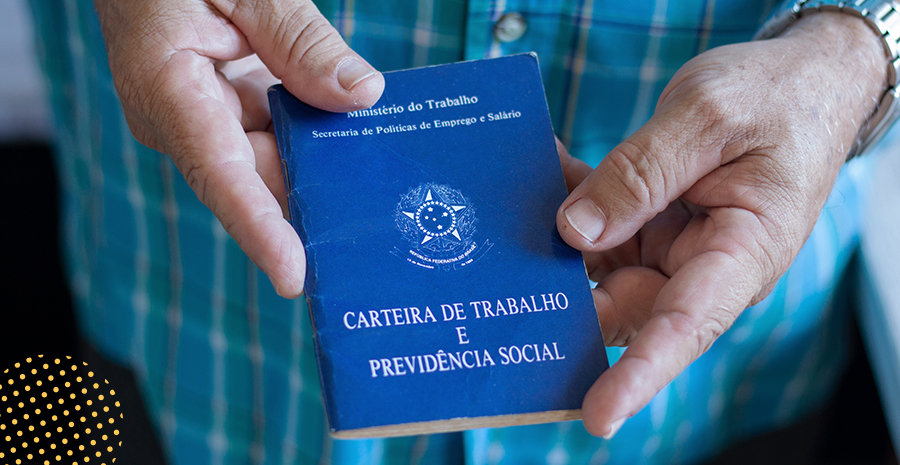 imagem de um homem segurando a carteira de trabalho e previdência social