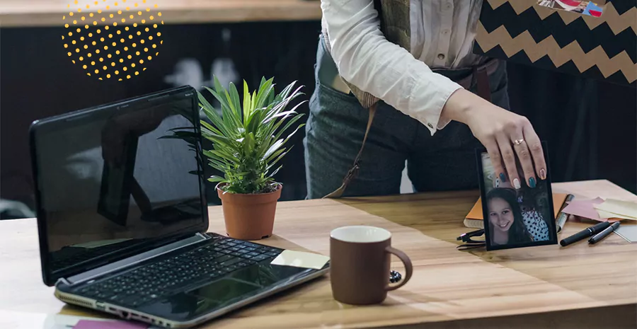 imagem de umhomem mexendo em uma mesa com um computador e uma xícara