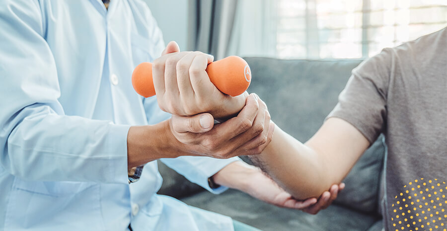 imagem de um médico ajudando outra a pessoa a se exercitar segurando um peso nas mãos