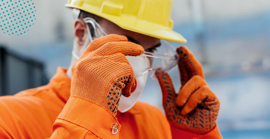 imagem de um homem usando equipamentos de proteção individual com luvas, capacete e óculos