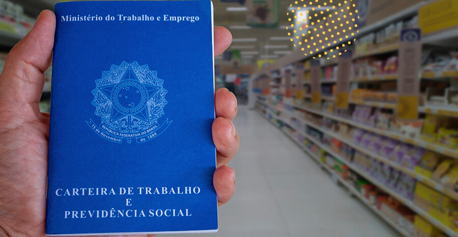 imagem com foco em uma mão segurando uma carteira de trabalho