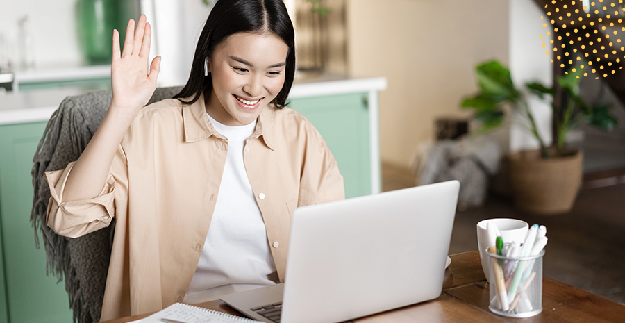 imagem de uma mulher sorrindo e levantando a mão na frente de um computador