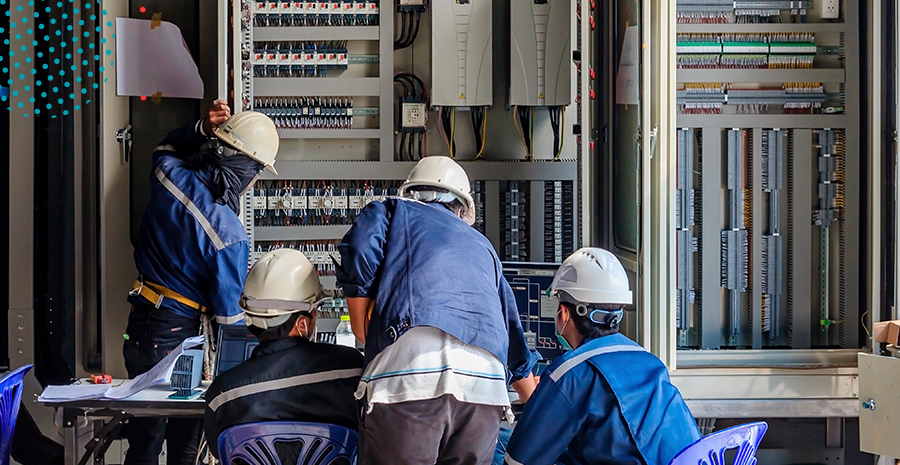 imagem de quatro pessoas consertando uma máquina