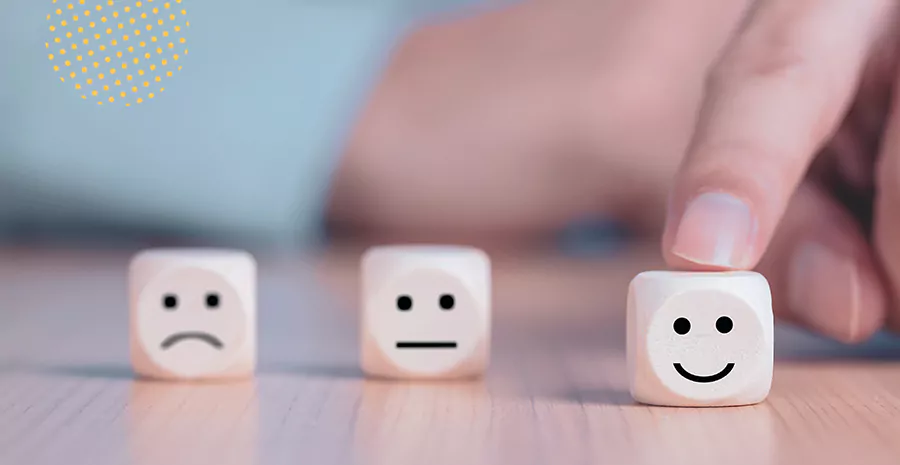 imagem de uma pessoa encostando em blocos brancos com desenhos sorrindo e tristes