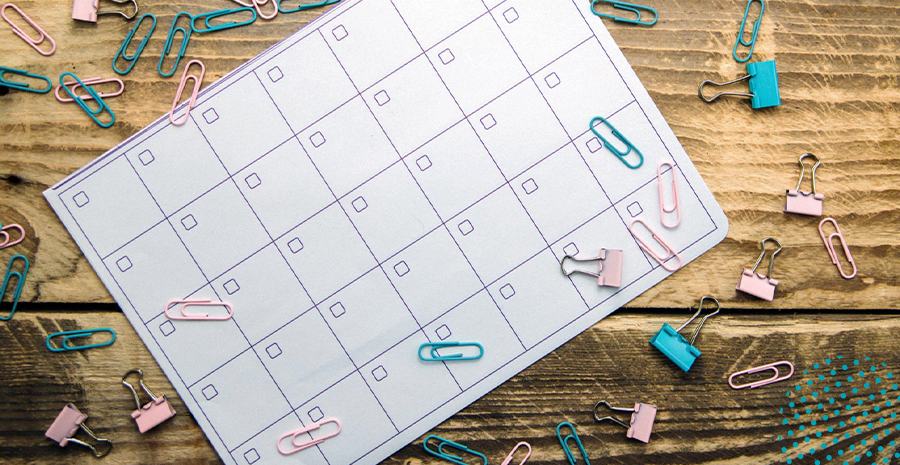 imagem de um calendário em cima de uma mesa com clips espalhados em cima