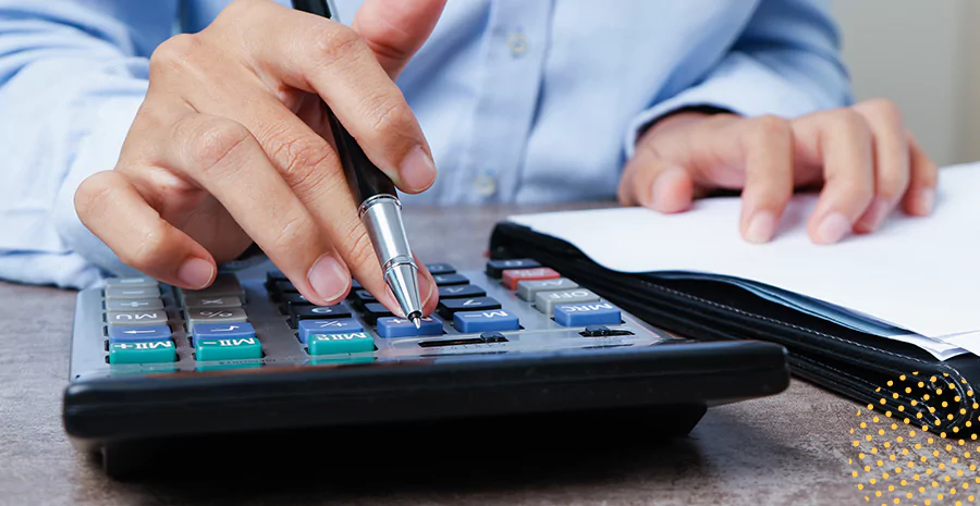 imagem de um homem usando uma calculadora e segurando uma caneta