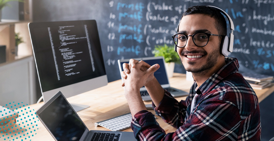 imagem de um homem sorrindo sentado na frente de um computador