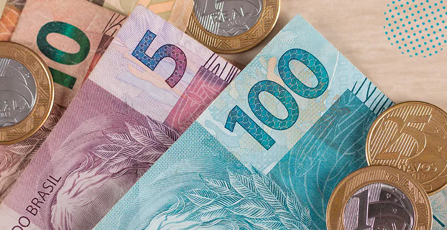 imagem de notas de cinco, vinte e cem reais, junto com moedas