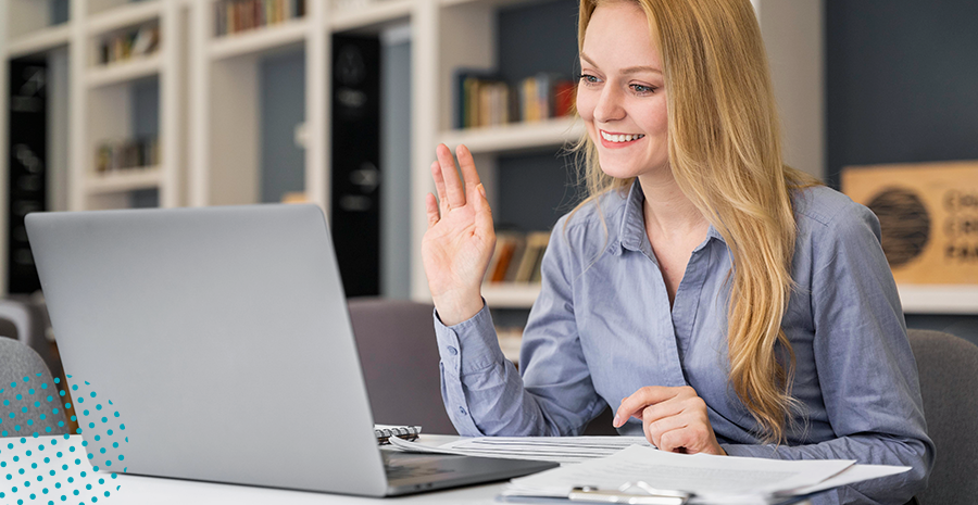 imagem de uma mulher sentada na frente de um computador erguendo a mão