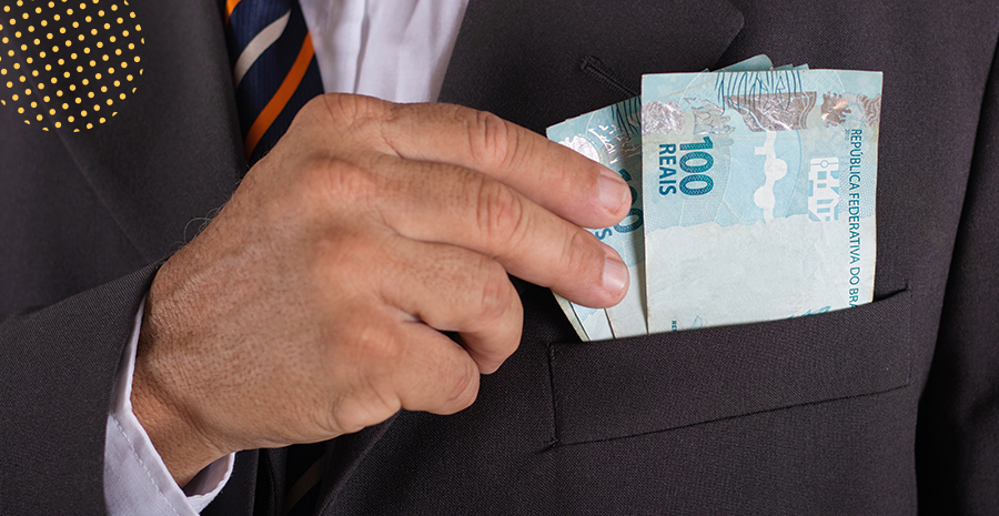 imagem de um homem colocando notas de cem reais no bolso de um paletó