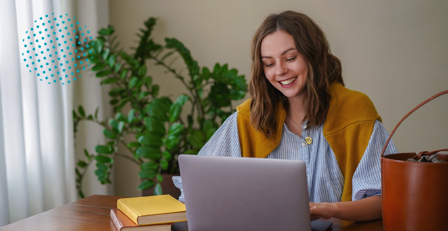 imagem de uma mulher sorrindo sentada na frente de um computador