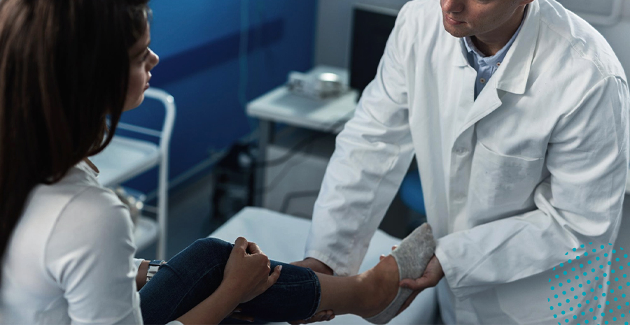 imagem de um médico examinando a perna de uma mulher