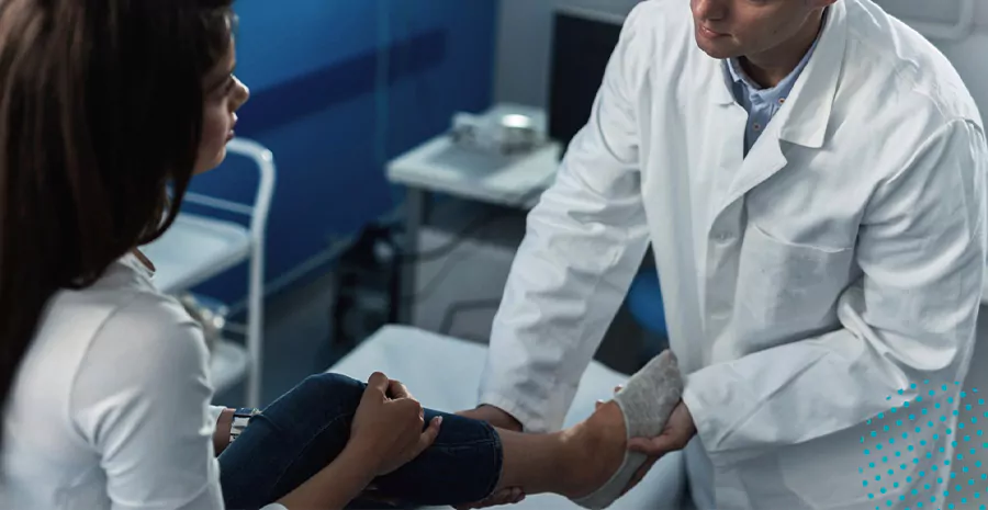 imagem de um médico examinando a perna de uma mulher