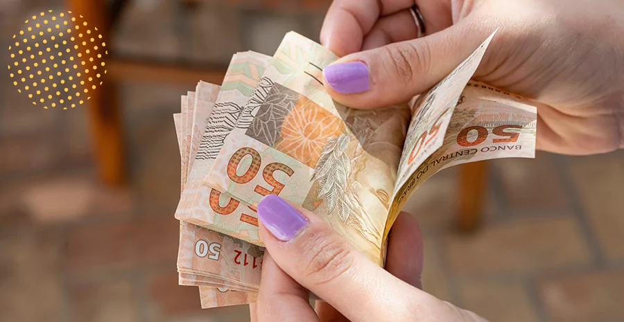 imagem de uma mulher segurando notas de cinquenta reais