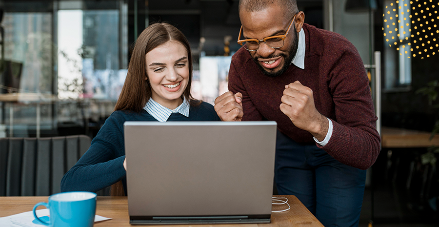 imagem de um homem e uma mulher olhando para um computador e sorrindo