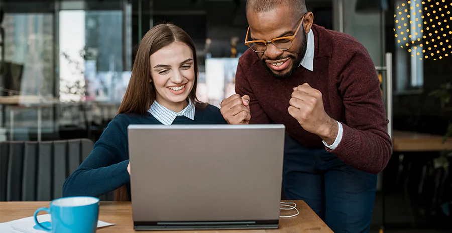 imagem de um homem e uma mulher olhando para um computador e sorrindo