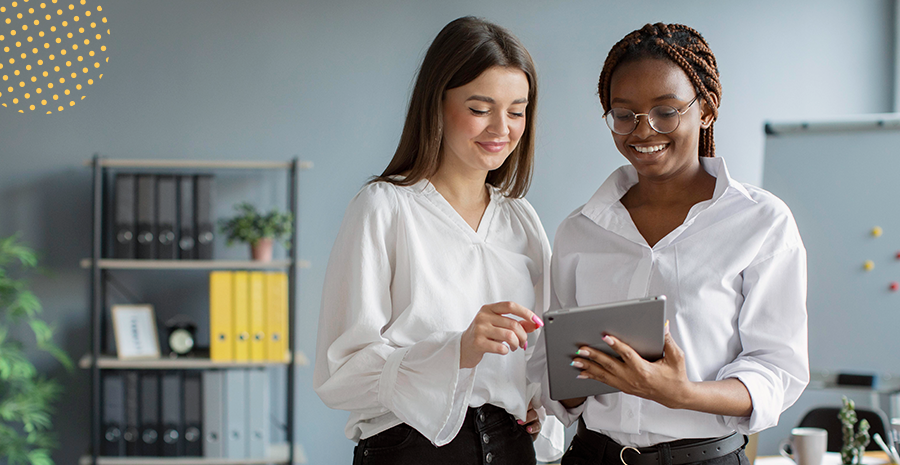 imagem de duas mulheres em pé olhando para um tablet