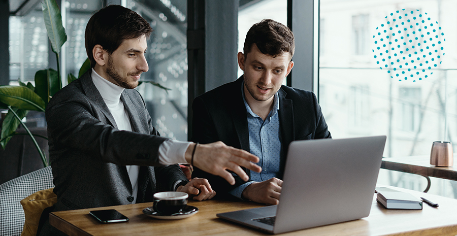 imagem de dois homens sentados olhando para um computador