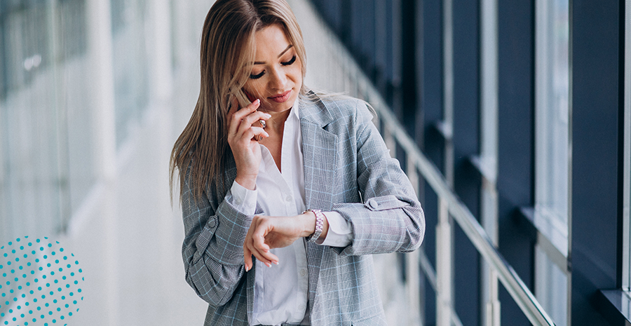 banco-de-horas-clt-beneficios Imagem de uma mulher falando no celular e olhando o relógio