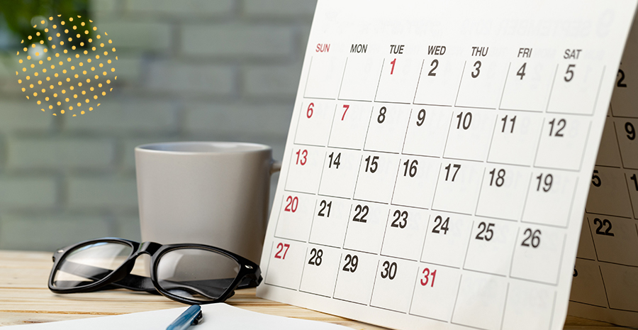 imagem de um calendário um óculos e uma xícara em cima de uma mesa