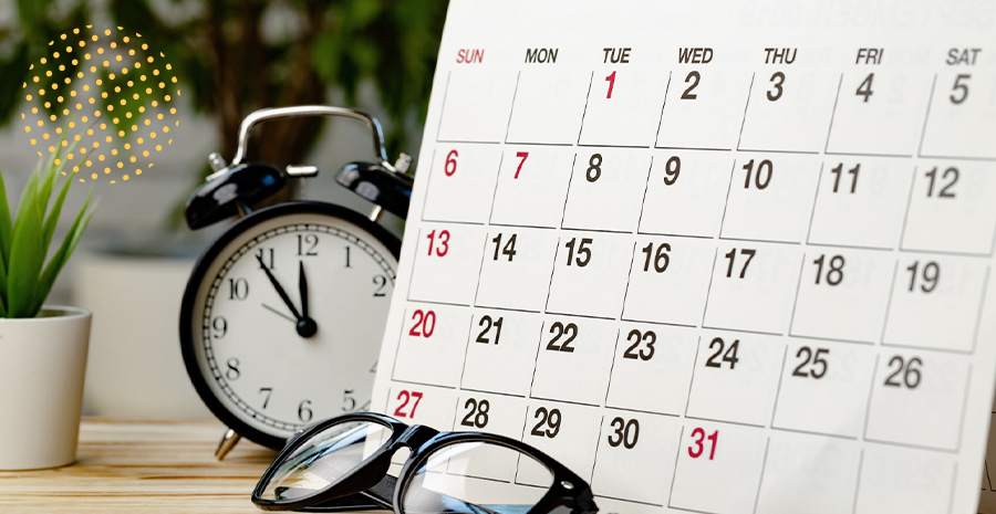imagem de um calendário, um óculos e um relógio em cima de uma mesa
