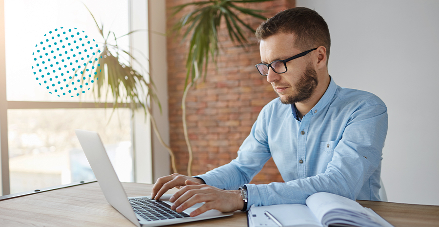 imagem de um homem sentado mexendo em um notebook
