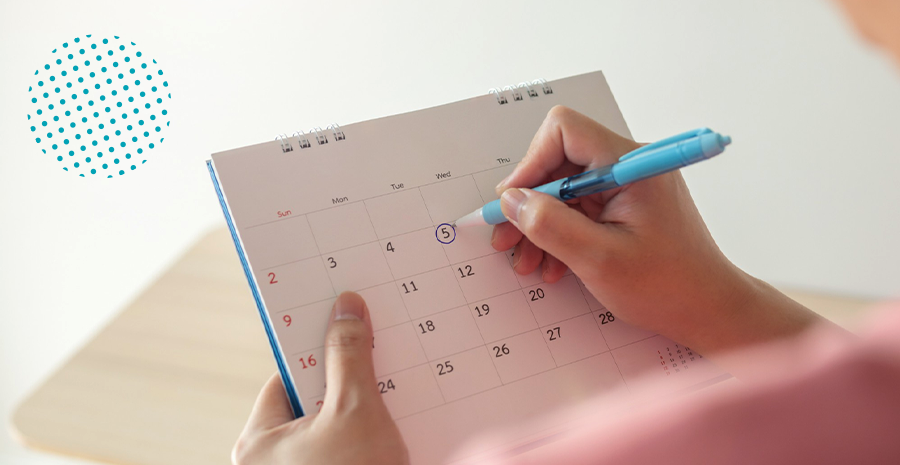 Uma pessoa escrevendo em cima de um calendário