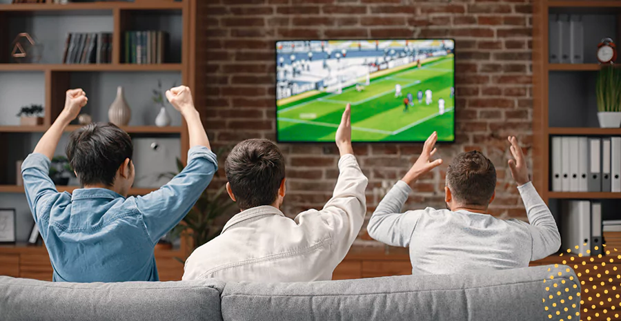 Três homens assistindo um jogo de futebol