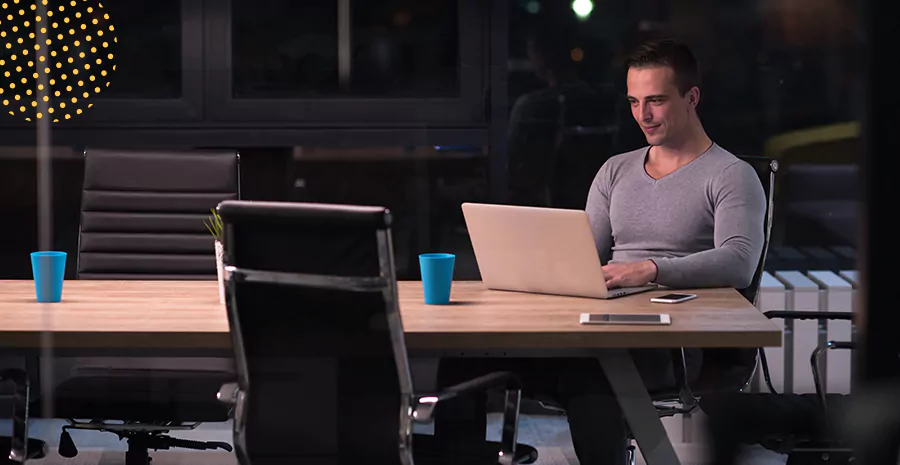 imagem de um homem sentado mexendo em um computador, representando como calcular horas extras