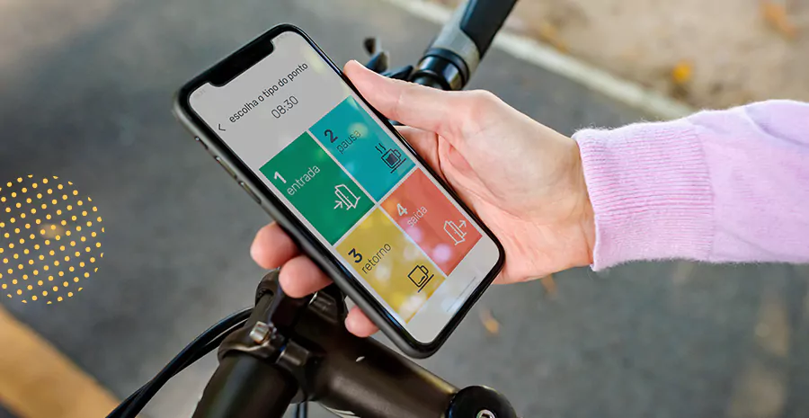 guidão de bicicleta ao fundo com pessoa segurando o celular na tela de bate ponto da PontoTel